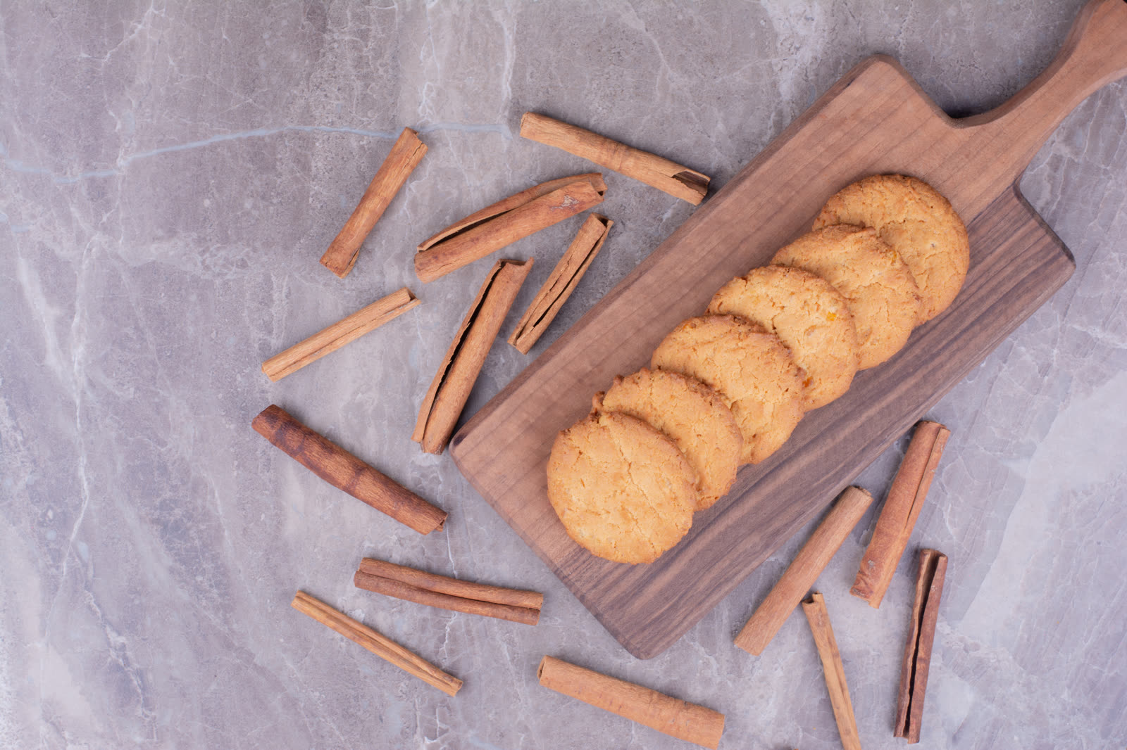 Butter cookies with cinnamon sticks on wooden platter