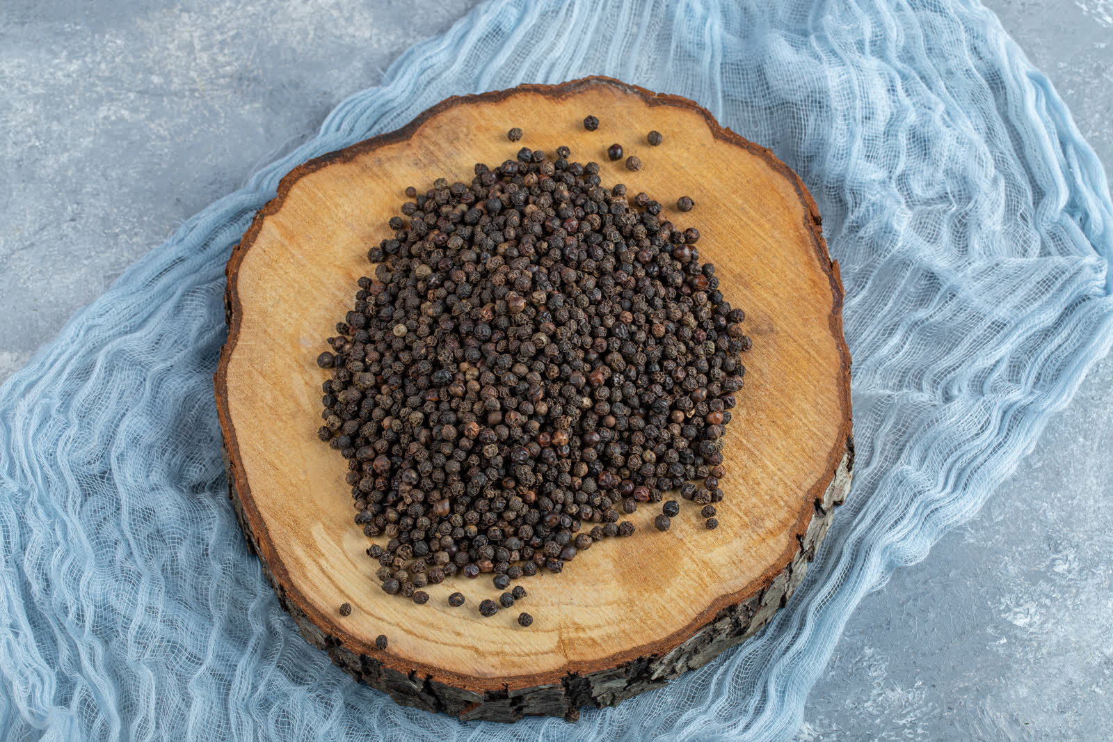A wooden board full of dried peppercorns