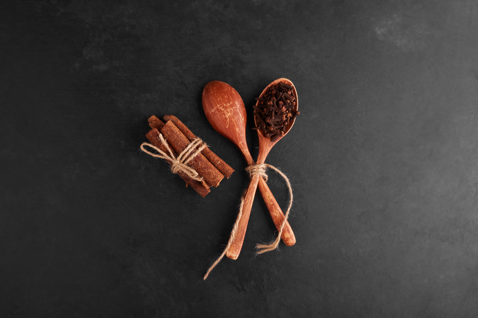 Cloves and cinnamons in a wooden spoon